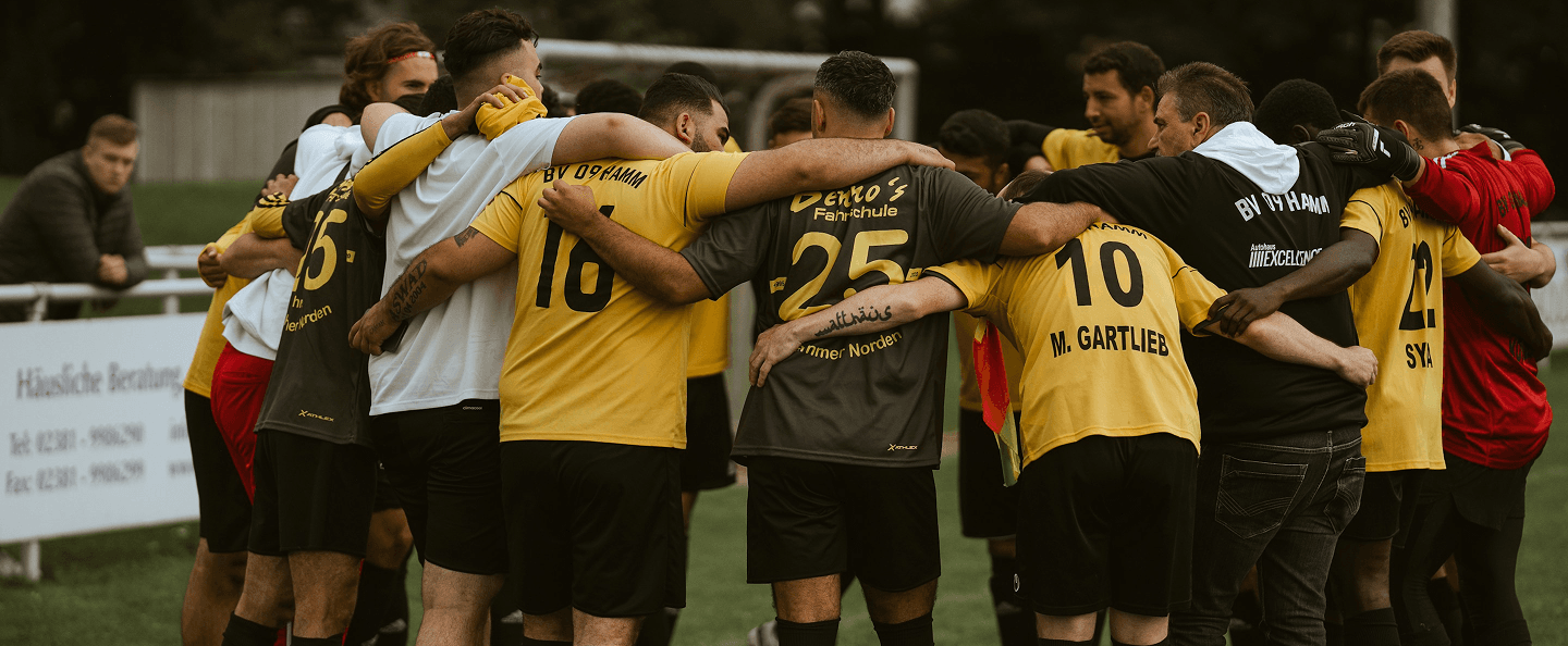 Football team huddled together on the pitch